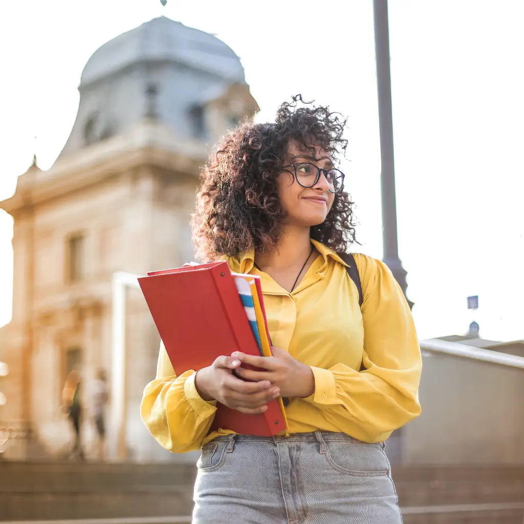 A university student looking into the distance smiling.