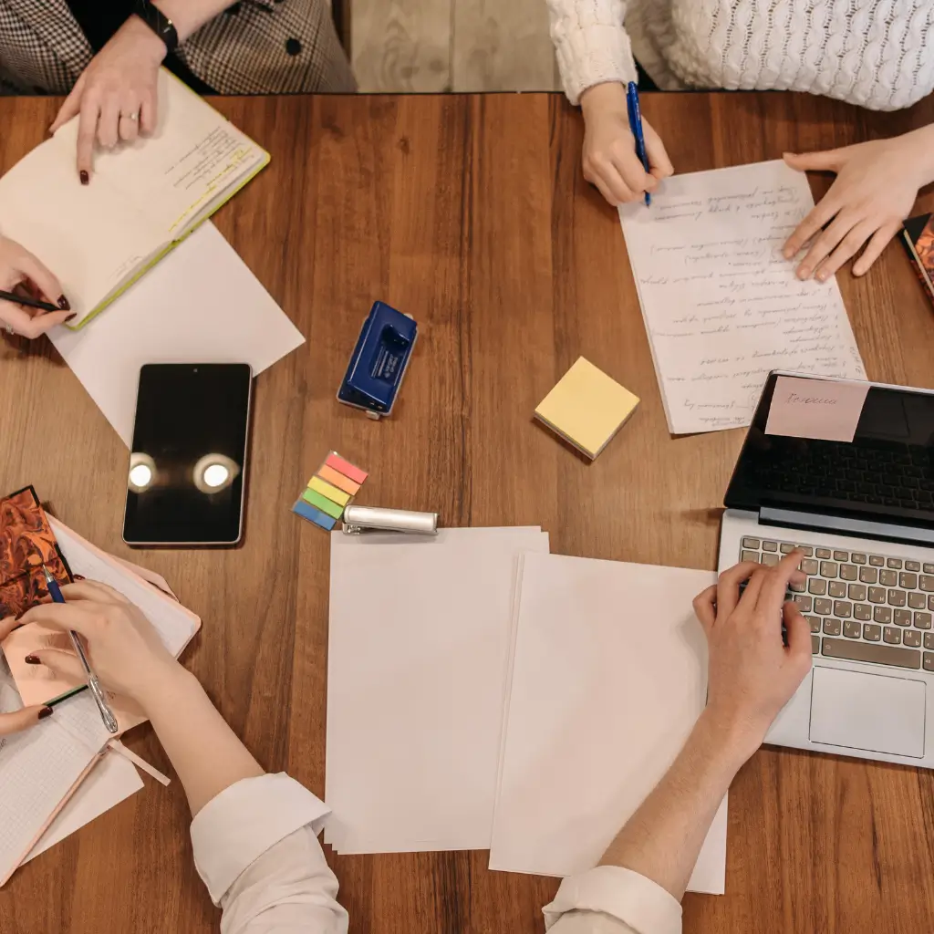 A group of four university students studying together at a desk.