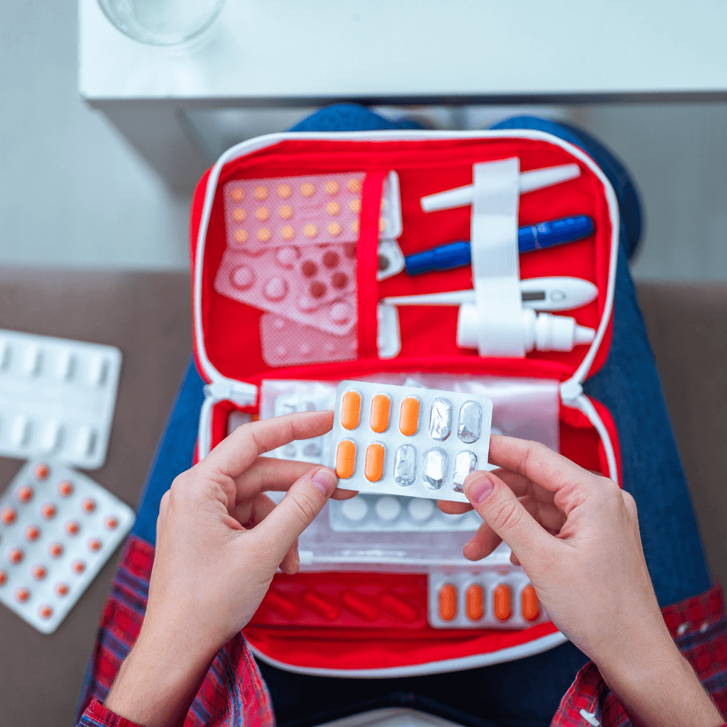 A person packing their medications in preparation for travel.